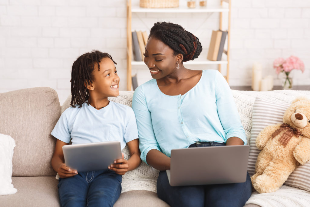 Child and parent using laptops