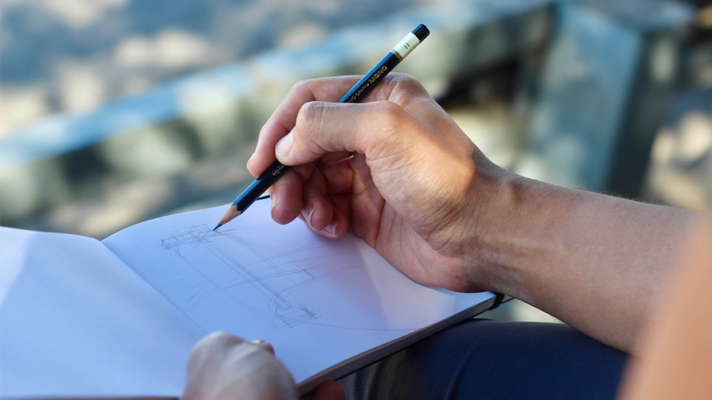 A person drawing in a sketchbook